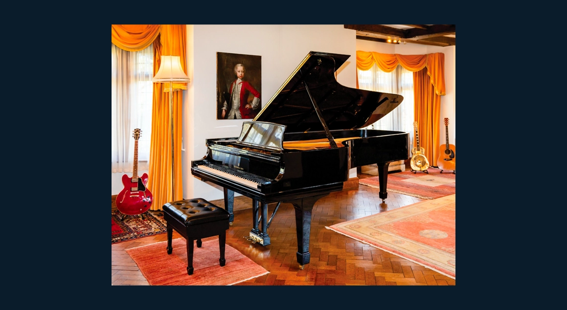 Grand piano with open lid in concert hall setting